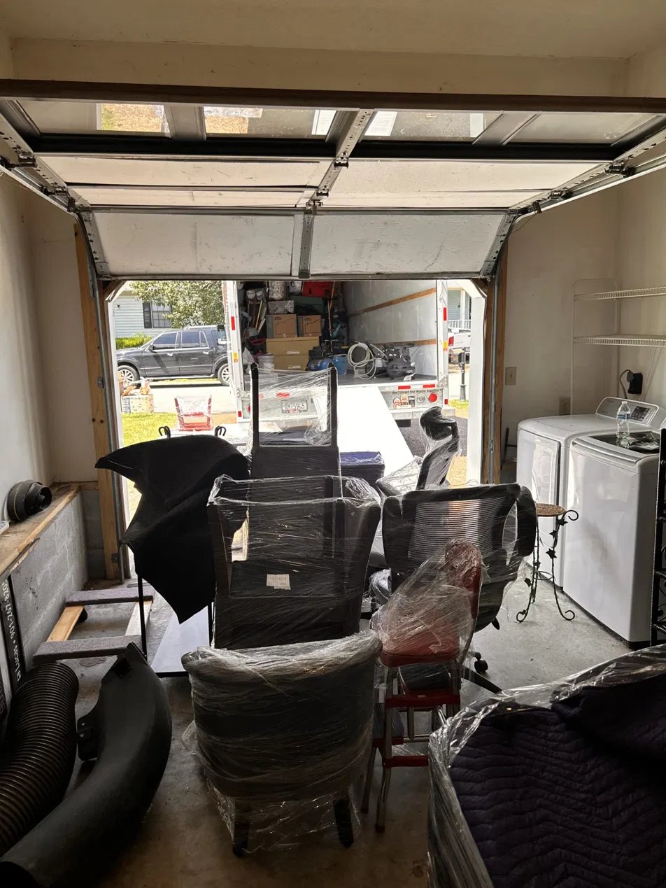 SmartStack Moving crew staging wrapped furniture in a garage before loading a rental truck in Middle Tennessee